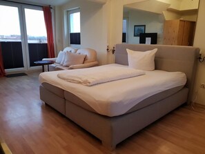 Une chambre moderne avec un grand lit, un canapé et une petite table.