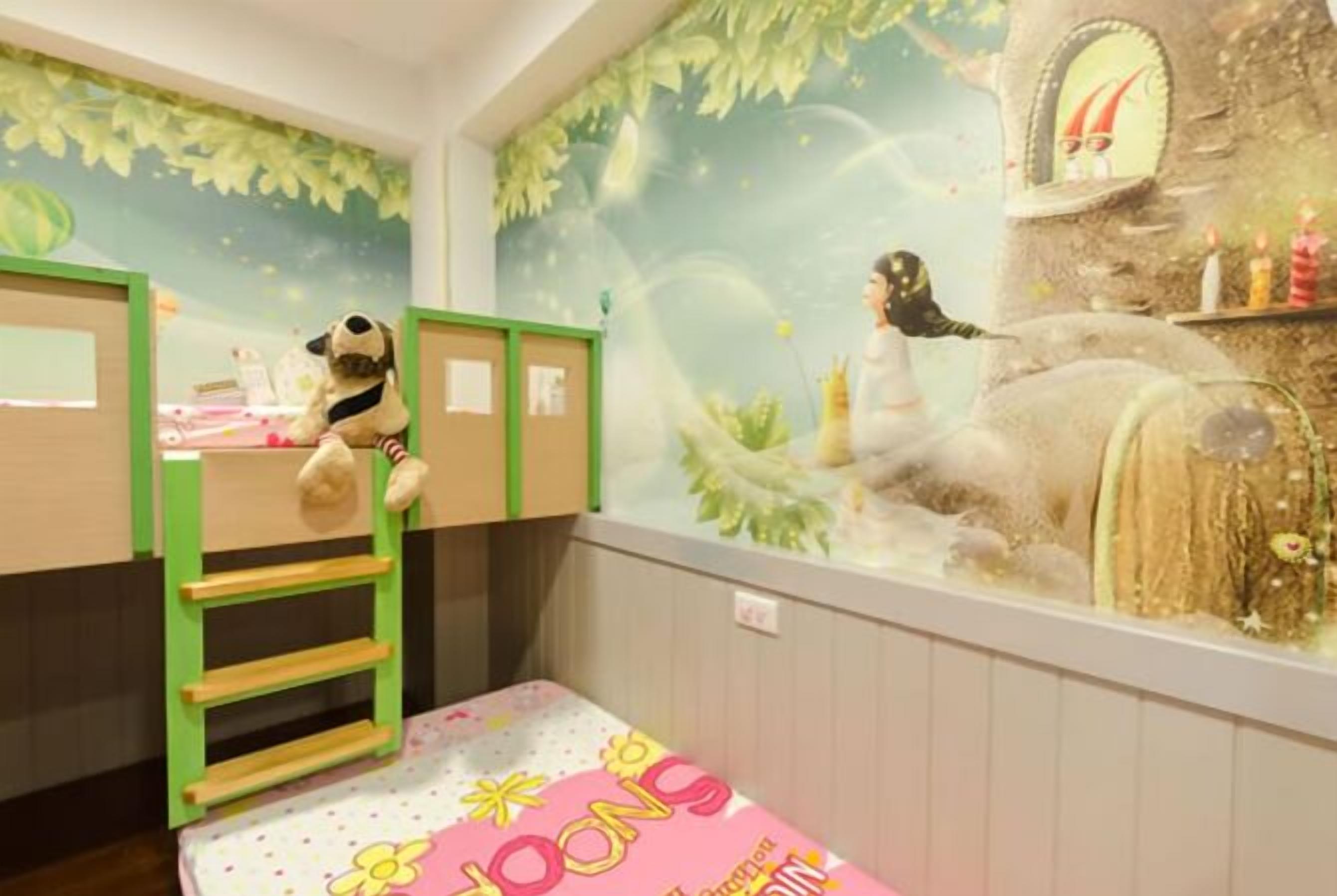 Un cuarto de juegos infantil con literas, una escalera y un mural con una escena de cuento de hadas.