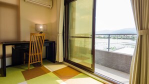 A room with a desk, chair, and a large window with a view of a bridge and mountains. - Easylife B&B  (Dongshan)