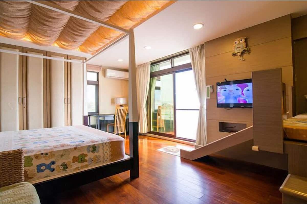 A modern bedroom with a bed, a TV, and a large window.