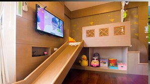 A children's play area with a slide, a playhouse, and toys. - Easylife B&B  (Dongshan)
