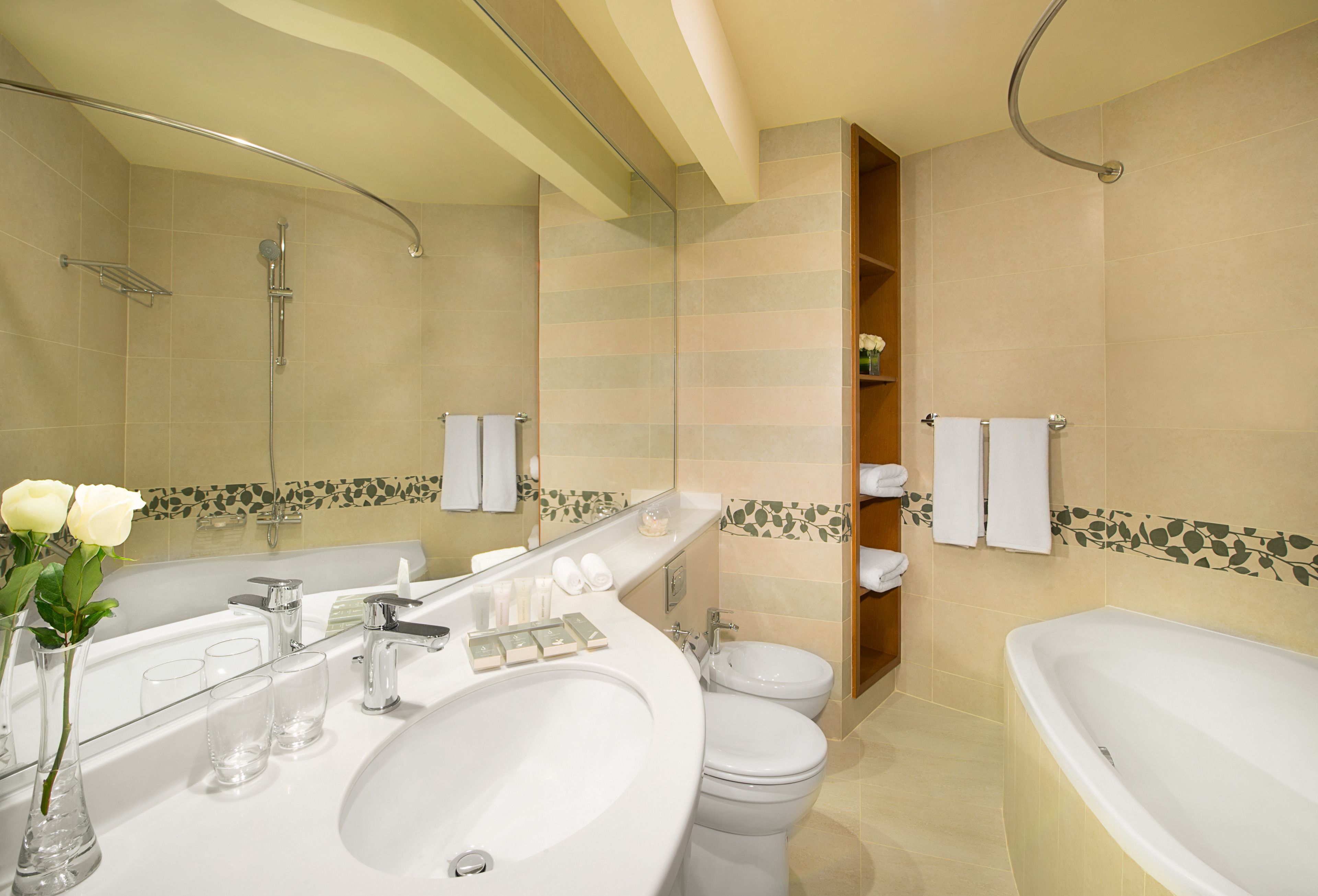 A modern bathroom with a large sink, two toilets, a bathtub, and a shower.