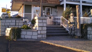 A two-story building with a porch, stone steps, and a statue. - Rip Van Winkle Motel (Plattsburgh)