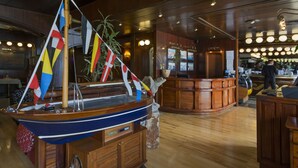 Un modelo de barco de madera con banderas, una zona de bar y muebles de madera.