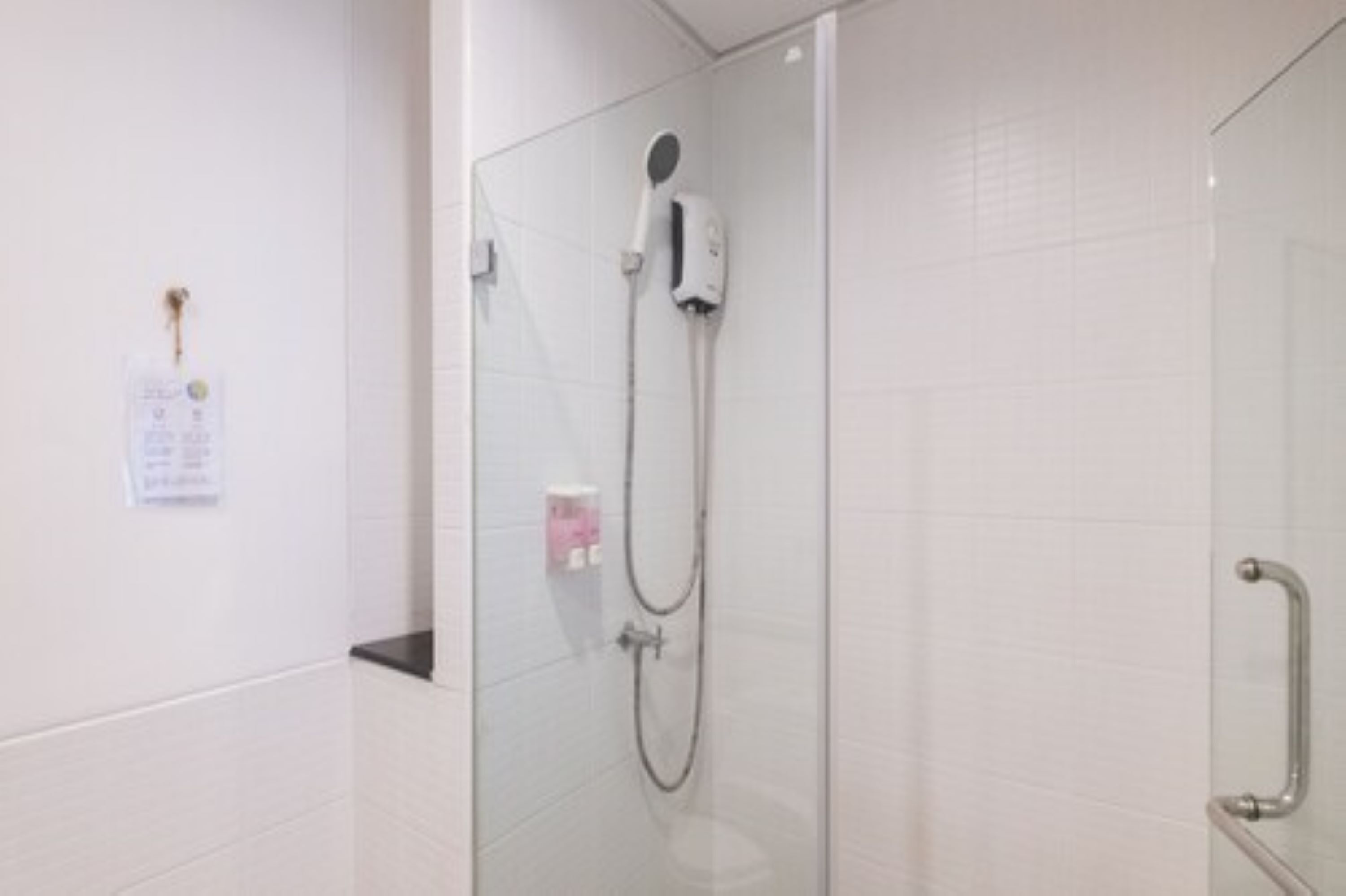 A modern shower with a handheld showerhead and a handheld soap dispenser.