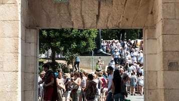 Una estructura de piedra arqueada con una multitud de personas abajo.