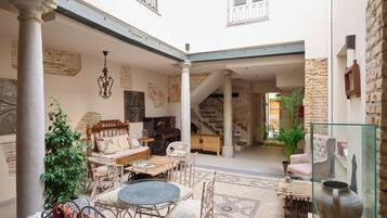 A spacious courtyard with a seating area, a staircase, and a glass display case.