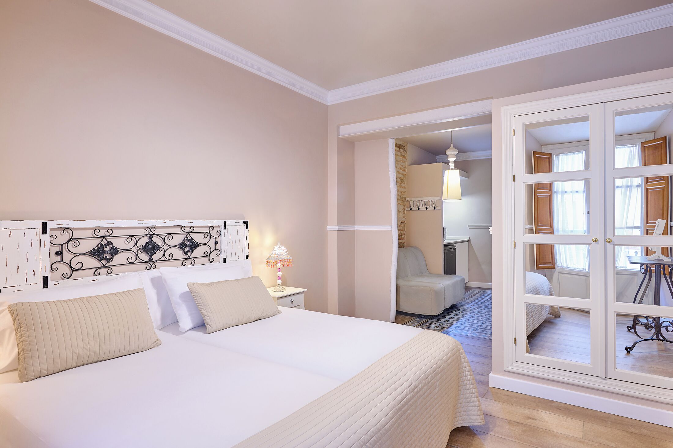 Une chambre à coucher avec un grand lit, une table de chevet, une lampe et une armoire avec un miroir.