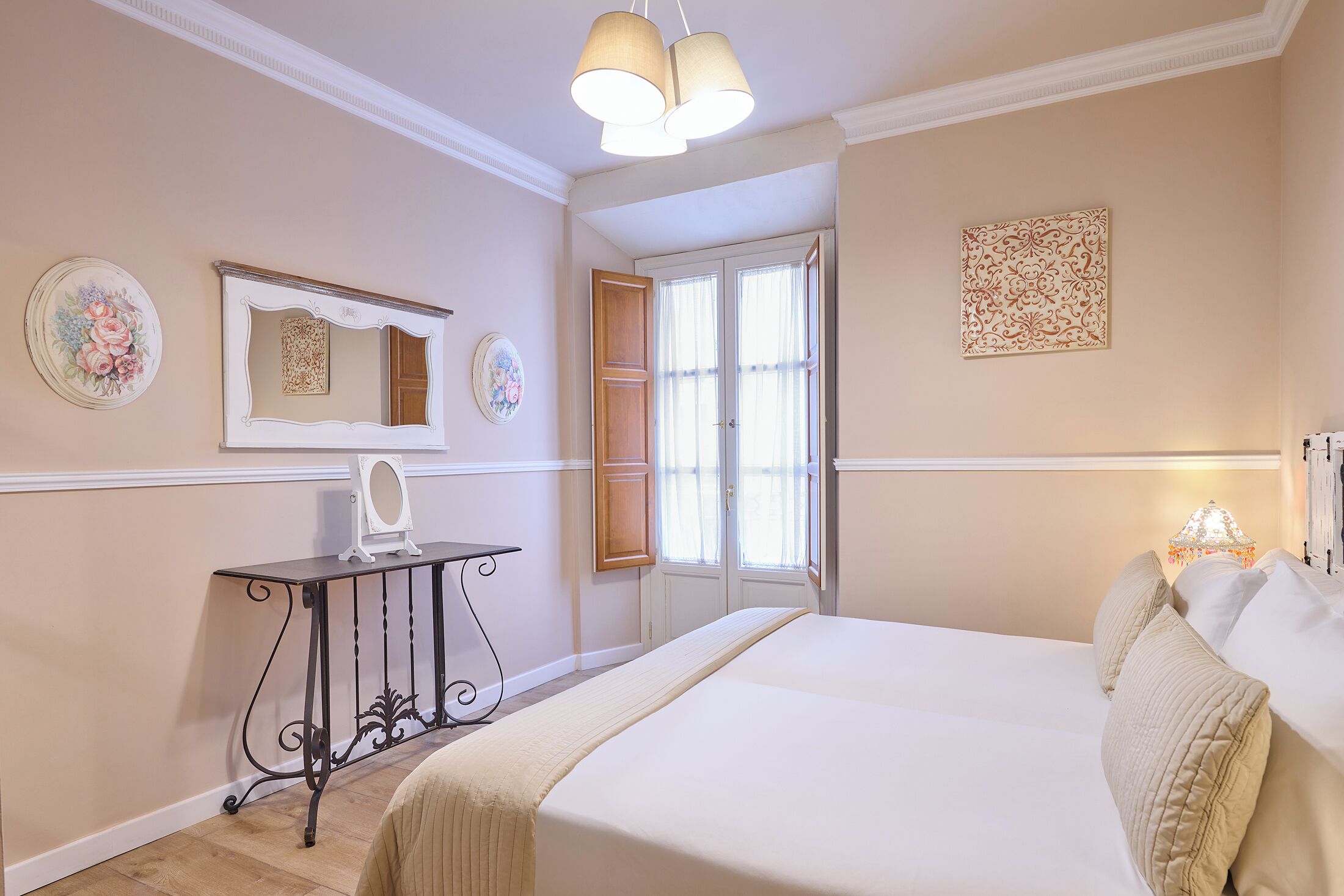 Une chambre à coucher avec un lit, une table de chevet, un miroir, une fenêtre et une porte.