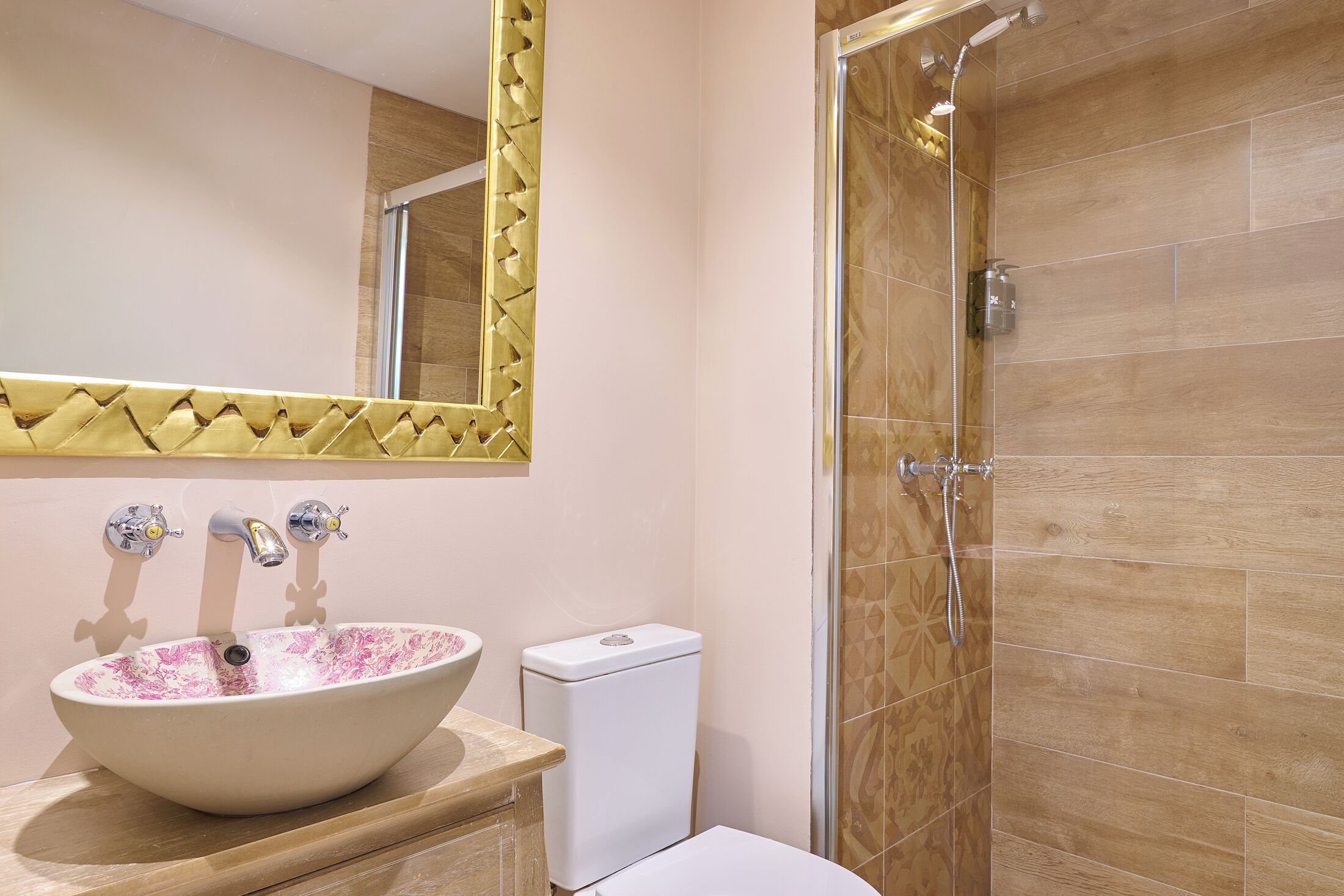 Un baño con lavamanos blanco, inodoro y cabina de ducha.