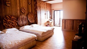 Una habitación con dos camas, paredes de madera y un ventanal grande.