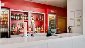 A bar area with shelves of liquor bottles, a cash register, and a sign indicating an offer for apple sour. - Travelodge Cardiff Atlantic Wharf Hotel (Cardiff)