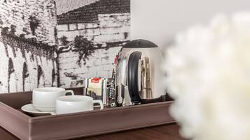 A tray with a coffee maker, cups, and a box of coffee.