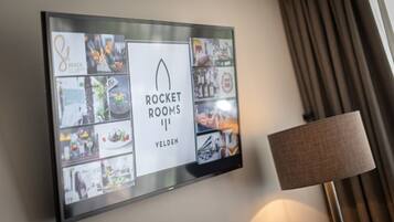 A wall-mounted display with the text "ROCKET ROOMS VELDEN" and various images of food and dining scenes.