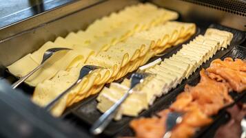 A buffet with various food items including pancakes, waffles, and salmon.