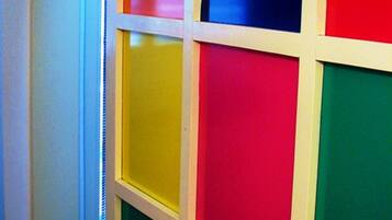 Un couloir dont les murs sont ornés de panneaux colorés disposés en forme de quadrillage.