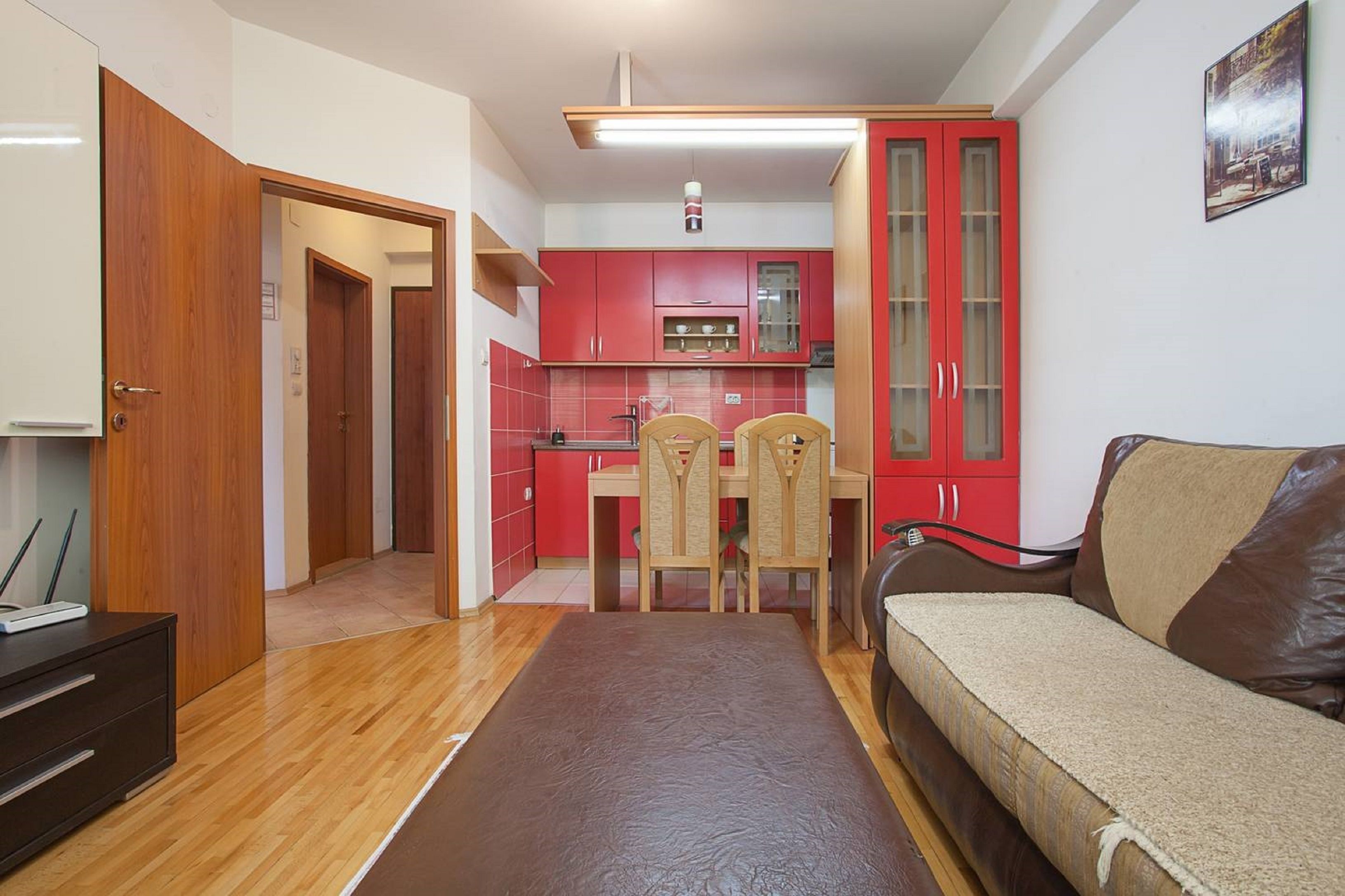 A compact living space with a kitchenette, a dining area, and a sofa.