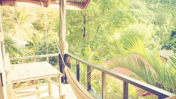 A hammock on a balcony overlooking a lush green landscape. - Reggae Village (Ko Pha-ngan)