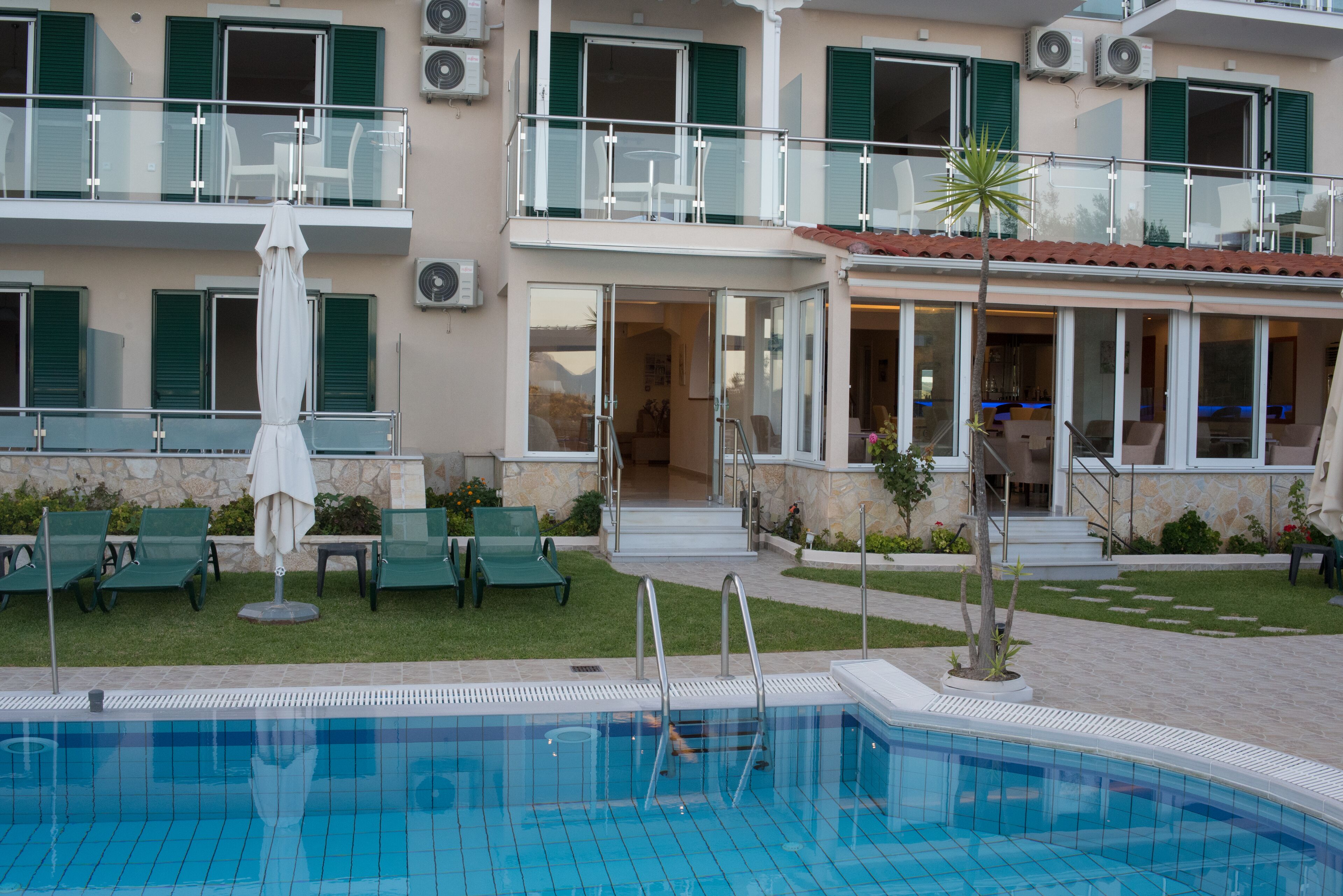 Un hotel con piscina, zona de estar al aire libre y balcón con vistas.