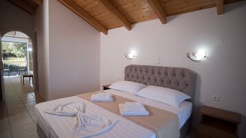 A bedroom with a large bed, two bedside tables, and a wooden ceiling.
