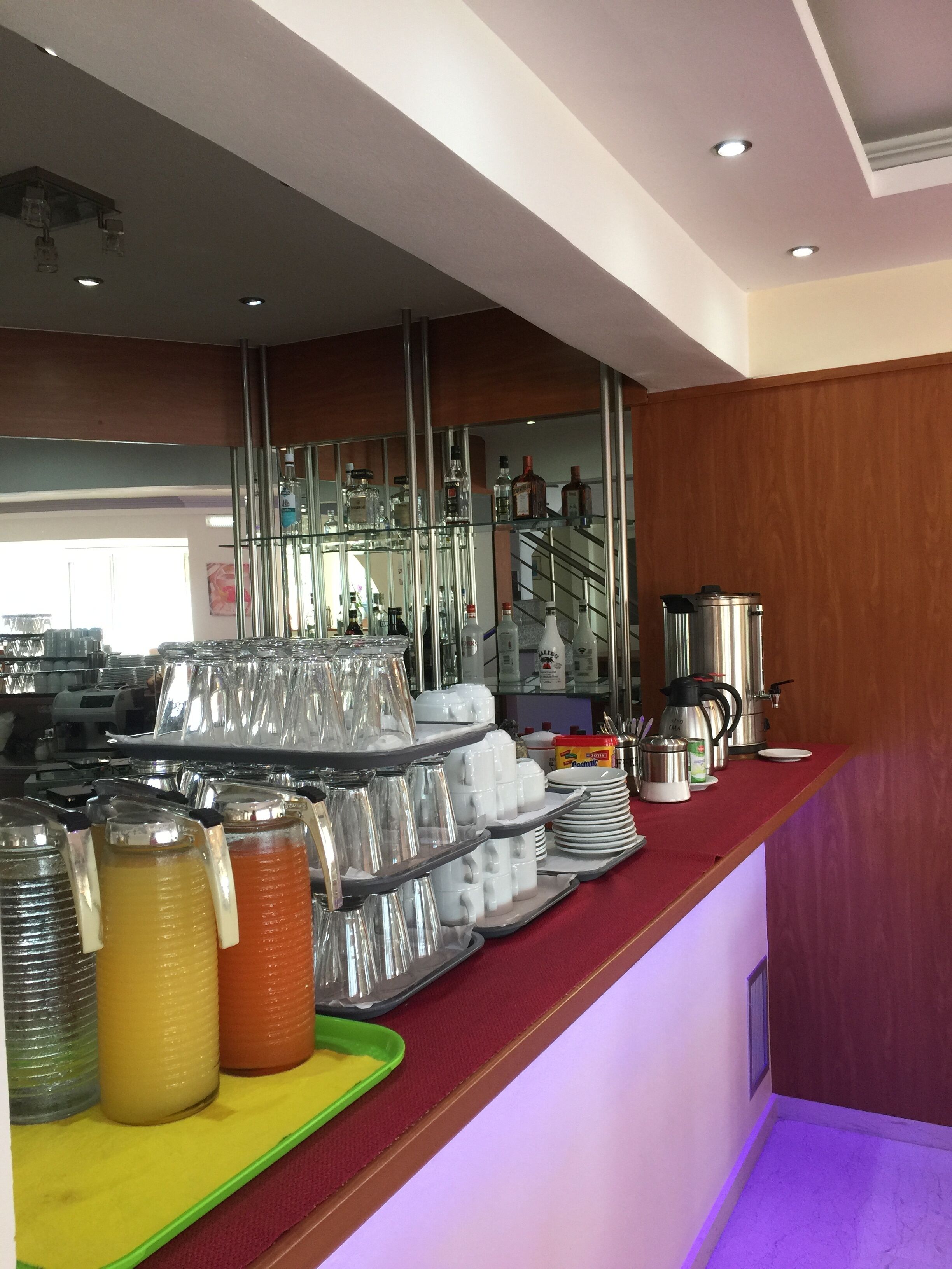 Un espace buffet proposant une variété de plats et de boissons, notamment une machine à café et une bouilloire sur le comptoir.