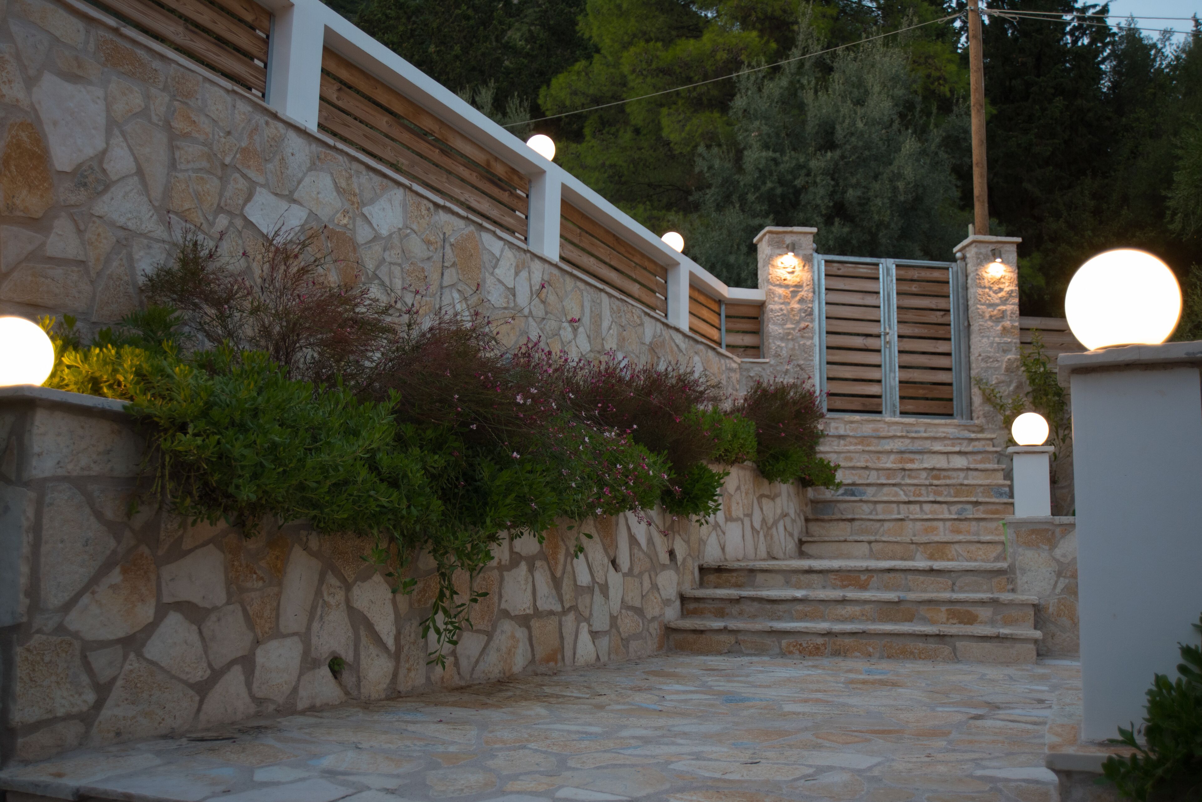 A stone staircase with wooden railings and a stone wall.