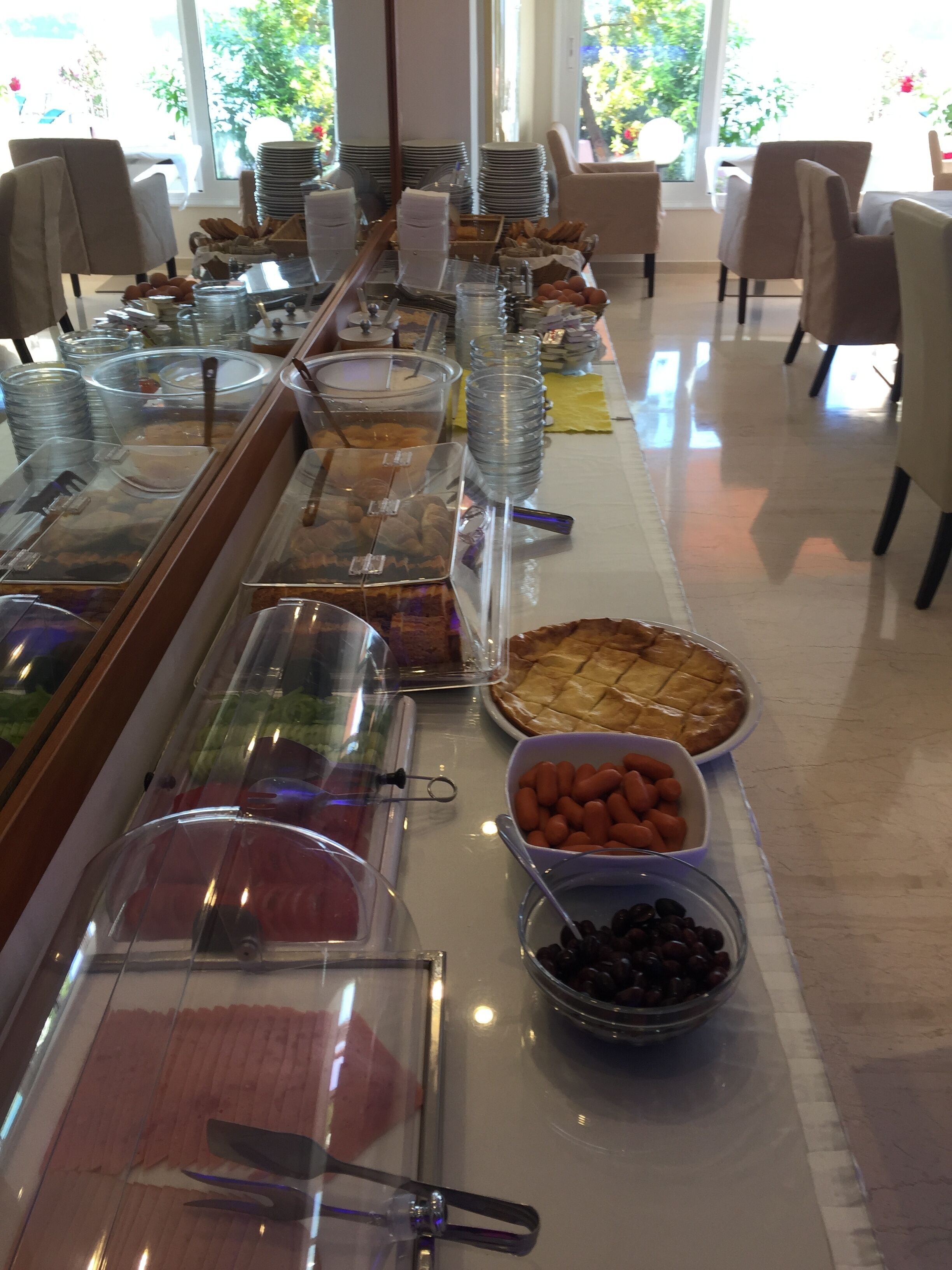 A buffet setup with various food items and clear containers.
