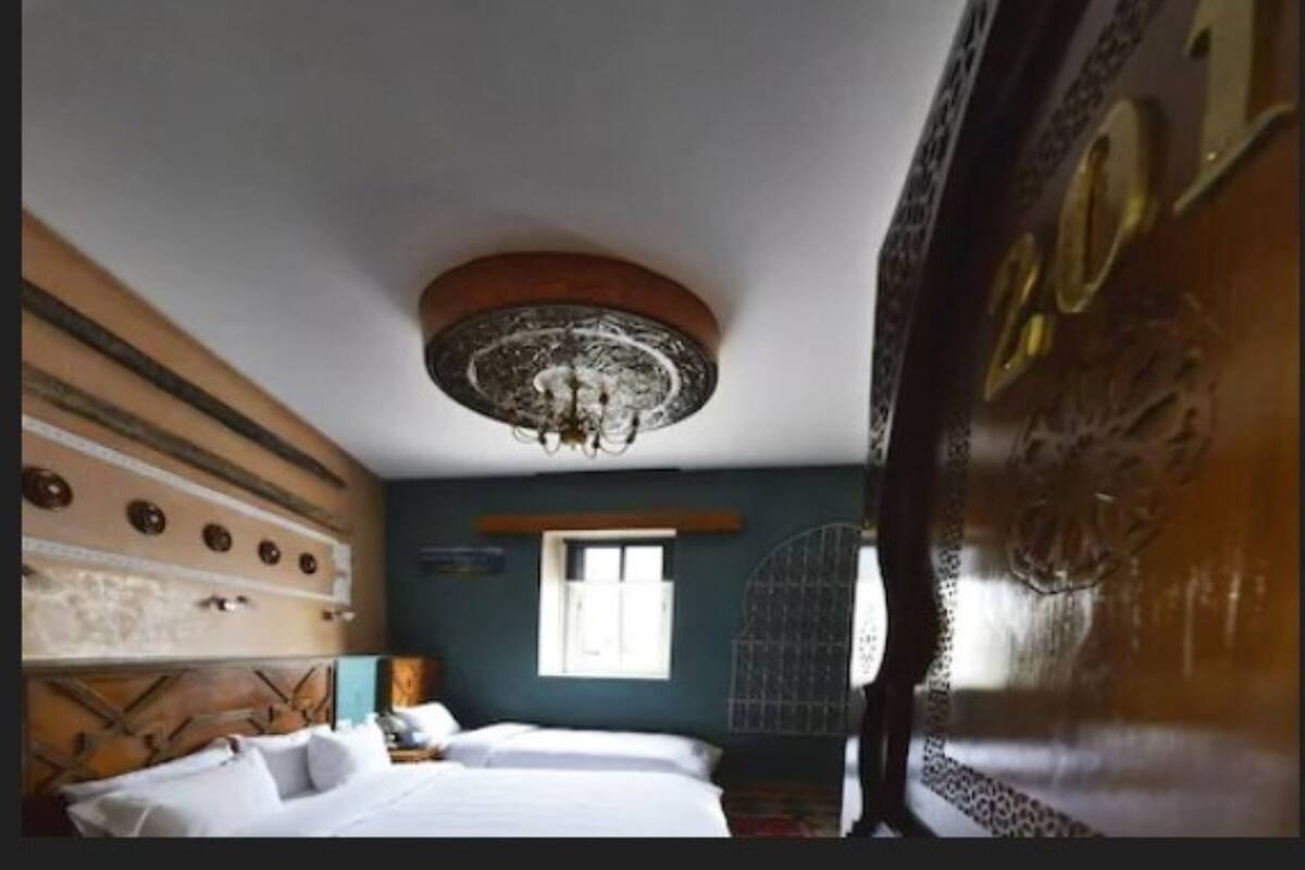 A room with a bed, a window, and a decorative ceiling.