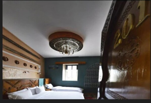Una habitación con cama, ventana y un techo decorativo.