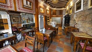 A traditional inn with wooden furniture, stone walls, and patterned decorations.