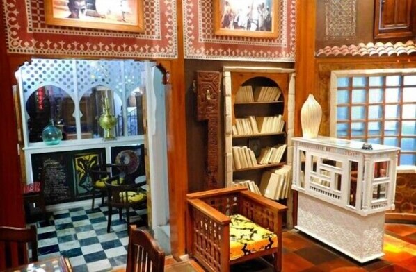 Una habitación con suelo a cuadros, muebles de madera, una estantería y un aparador decorativo.