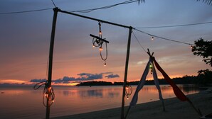 A beach scene with a tent and string lights against a sunset. - Hinkong Hut (Ko Pha-ngan)
