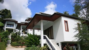 A modern building with a white exterior, a wooden staircase, and a covered outdoor area. - Hinkong Hut (Ko Pha-ngan)