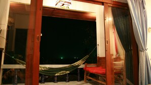A room with a large window, a hammock, and a red chair. - Hinkong Hut (Ko Pha-ngan)