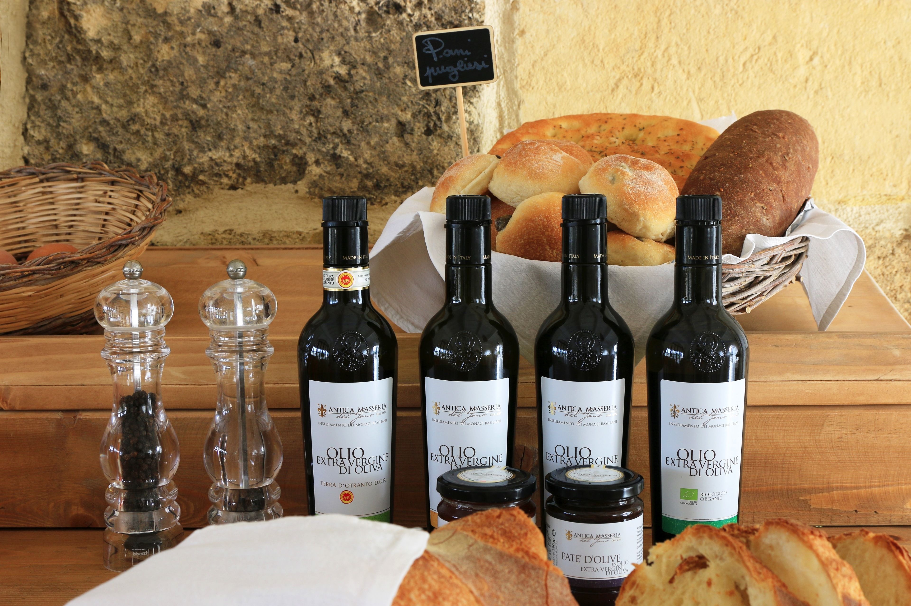 Ein Tisch mit Brot, Olivenölflaschen und Salz- und Pfefferstreuern.