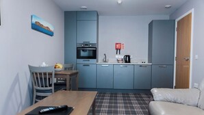 A compact living space with a kitchenette, a dining area, and a sofa. - The Ayre Hotel (Kirkwall)
