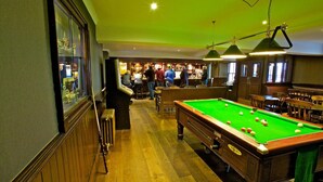 A pool table in a bar area with wooden flooring and green walls. - The Ayre Hotel (Kirkwall)