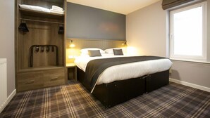 A bedroom with a bed, bedside lamps, a wardrobe, and a window. - The Ayre Hotel (Kirkwall)