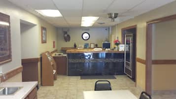 A restaurant with a marble counter, a registration sign, a wall-mounted deer head, and a sink.
