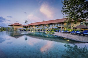 Um hotel com piscina, espreguiçadeiras e guarda-sóis.