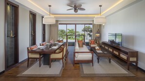 A dining area with a high ceiling fan, a television, and a view of greenery outside. - Anantara Kalutara Resort (Kalutara)