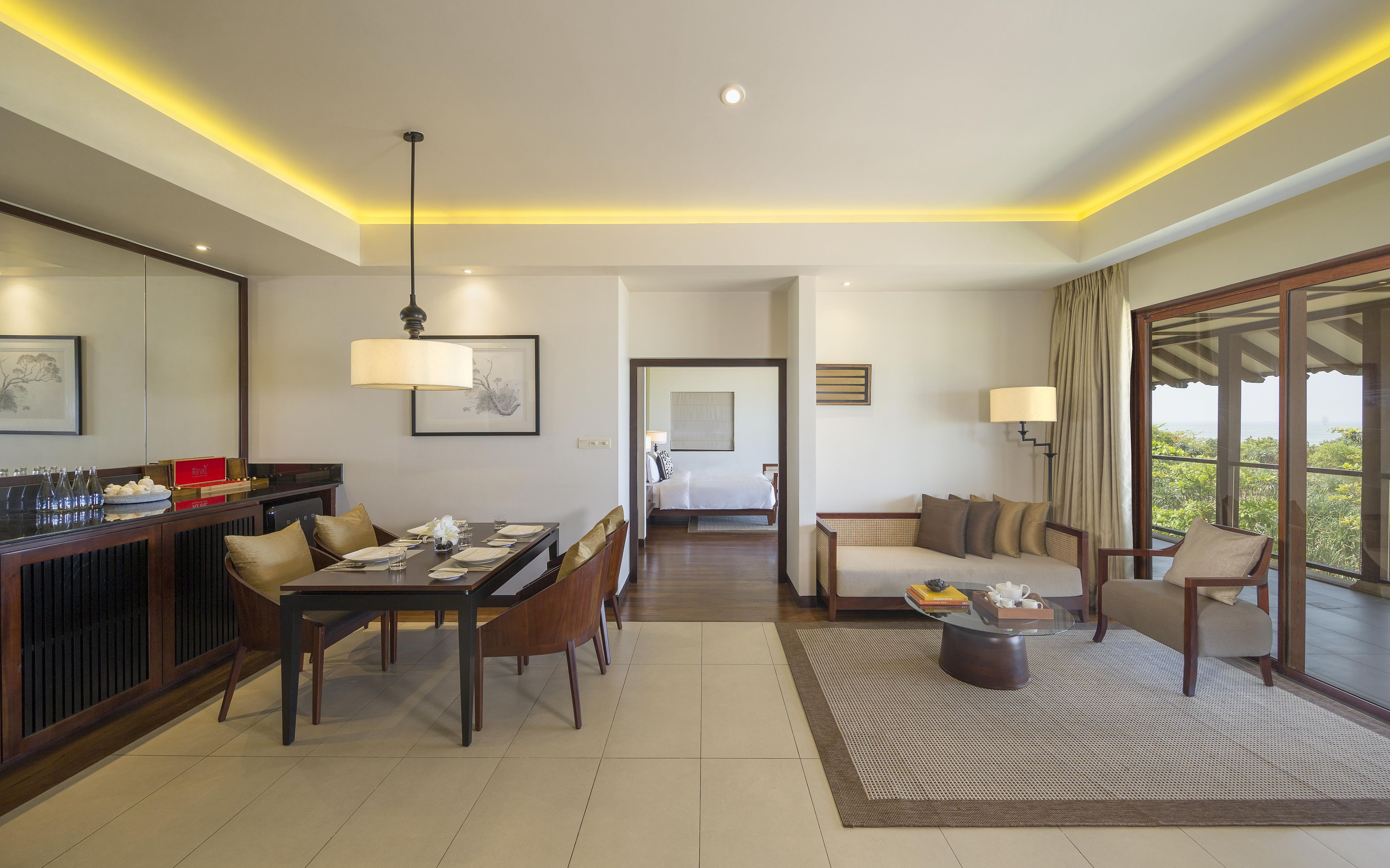 Ein modernes Hotelzimmer mit Essbereich, Wohnbereich und Schlafzimmer.
