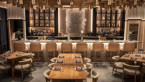 A modern bar area with wooden furniture and a central decorative wall. - Grand Hyatt Vail Resort and Spa (Vail)