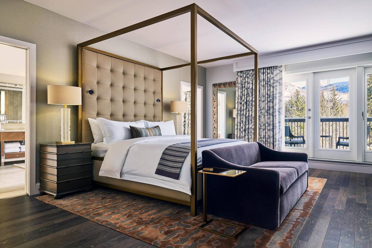 Ein Schlafzimmer mit Himmelbett, Nachttisch, Schminktisch und Blick ins Freie.