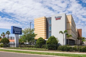 Ein Fairfield Inn & Suites Marriott Hotel mit modernem Design, das ein gut sichtbares Schild und eine gepflegte Grünfläche zeigt.