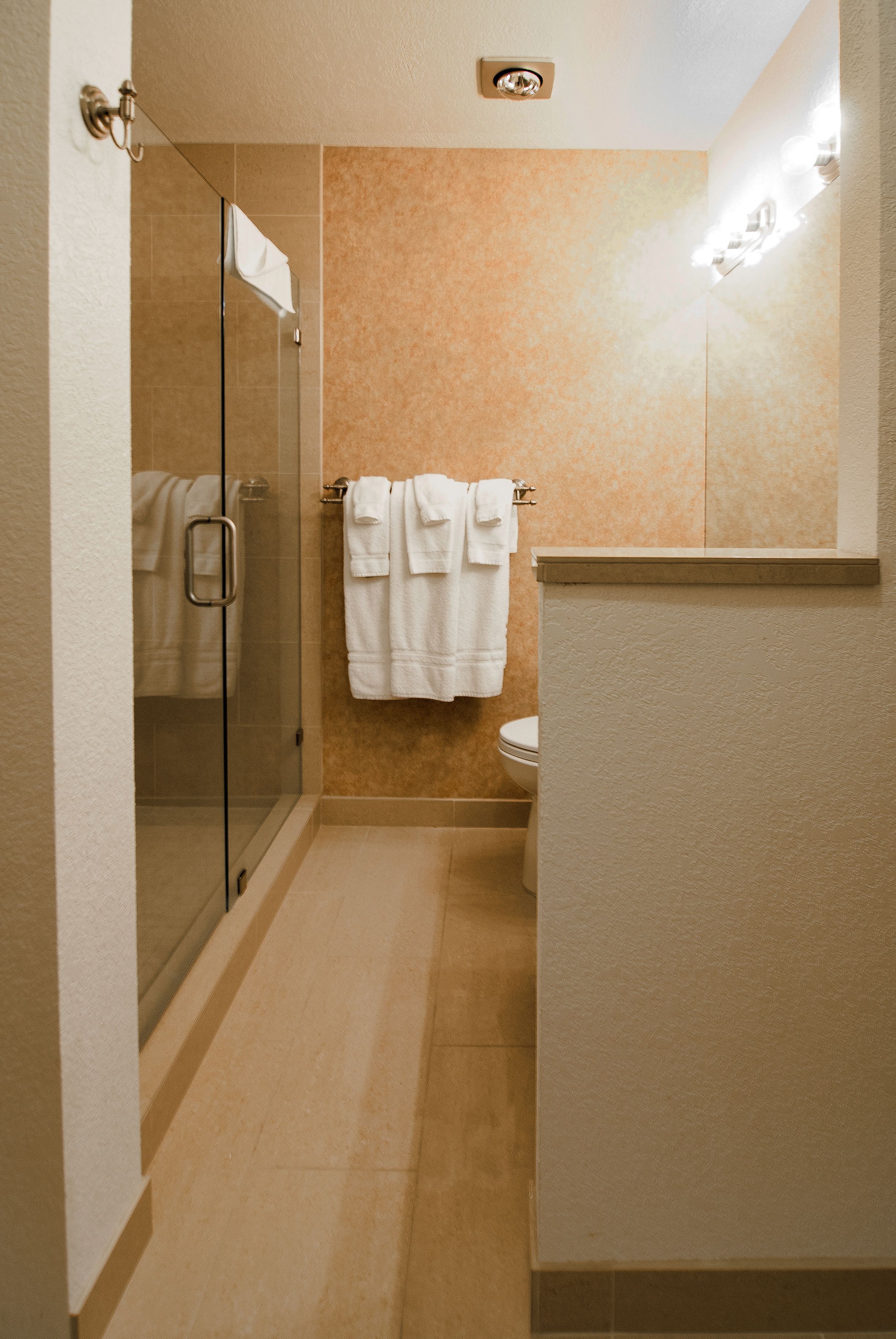 Une salle de bain avec une douche à parois de verre, des toilettes et un lavabo.