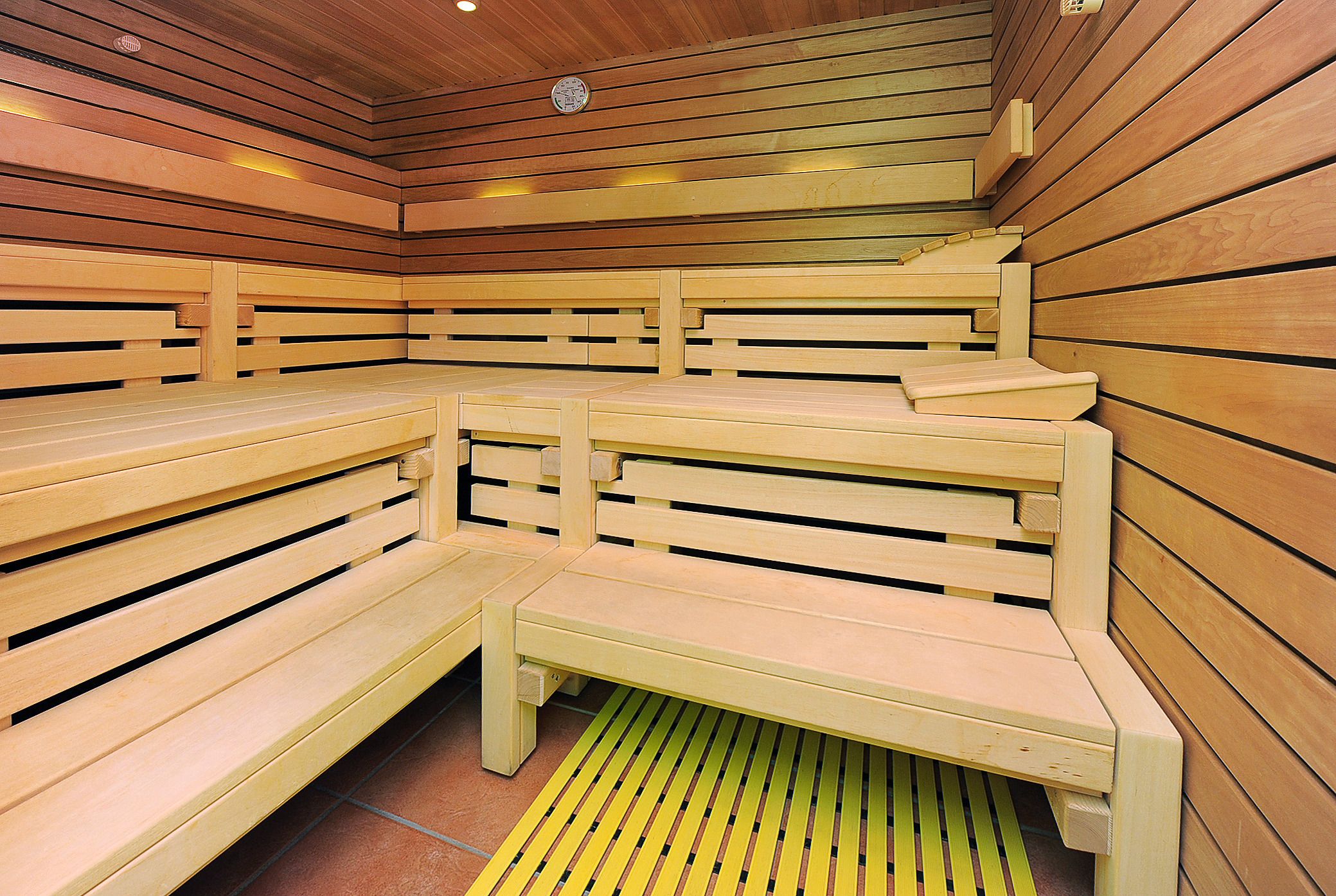 A sauna with wooden benches and a sloped ceiling.