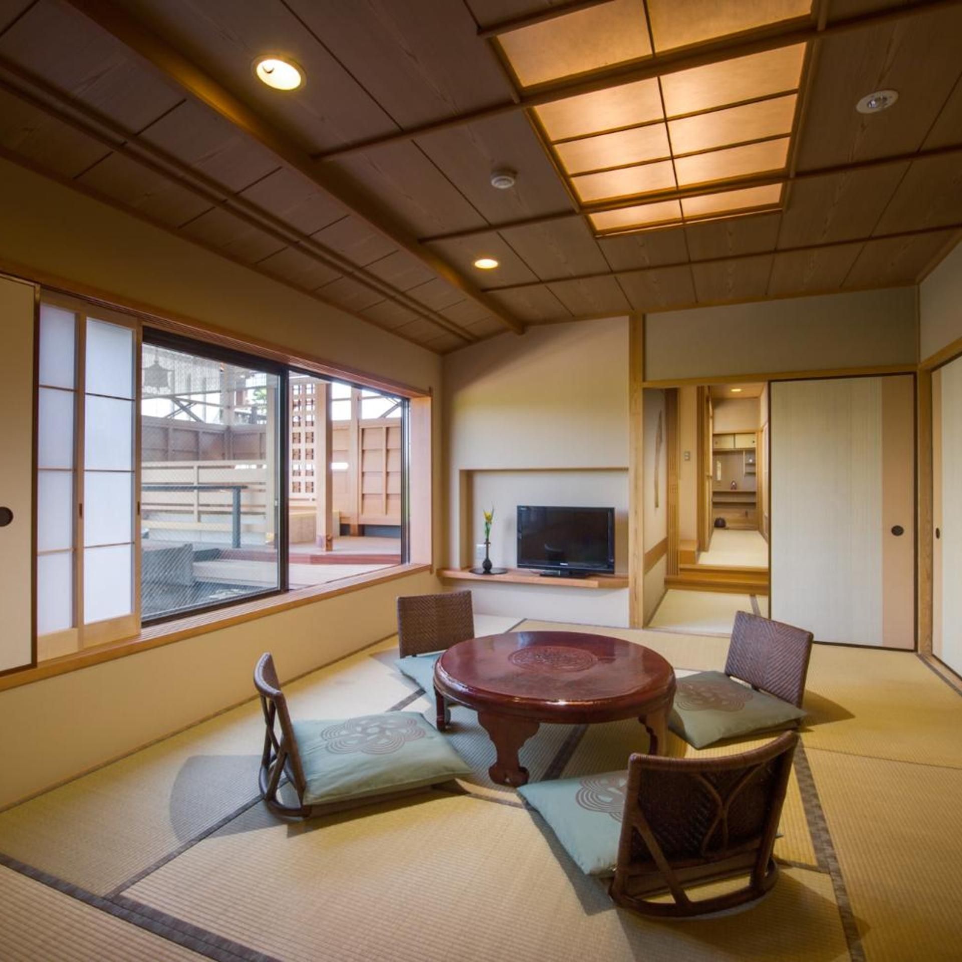 A traditional Japanese-style room with tatami flooring, a low wooden table, and shoji screens.