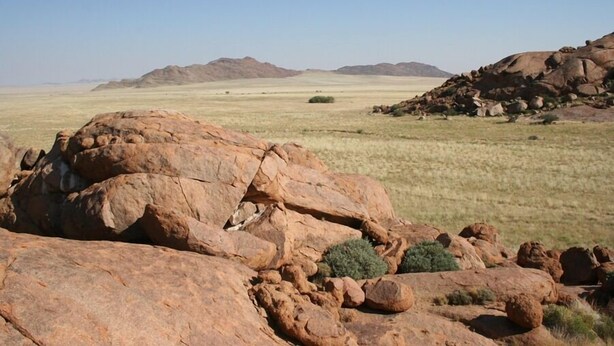 A rocky landscape with large boulders and sparse vegetation.