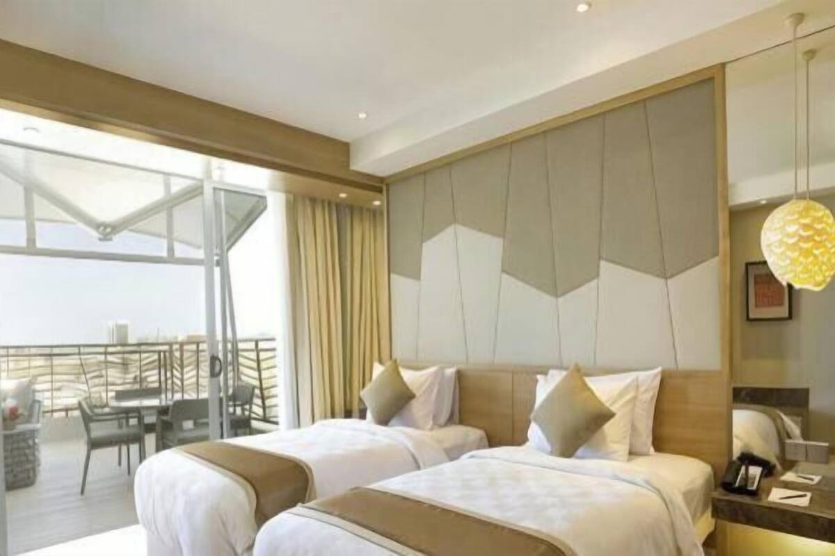 Une chambre d’hôtel avec deux lits, un balcon et un aménagement intérieur moderne.